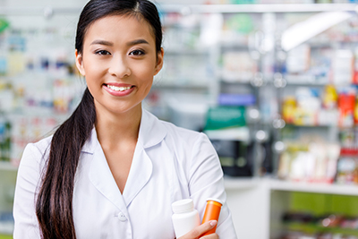 Young Pharmacist smiling while holding medicine