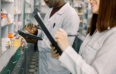 Close up of male and female pharmacists using tablets